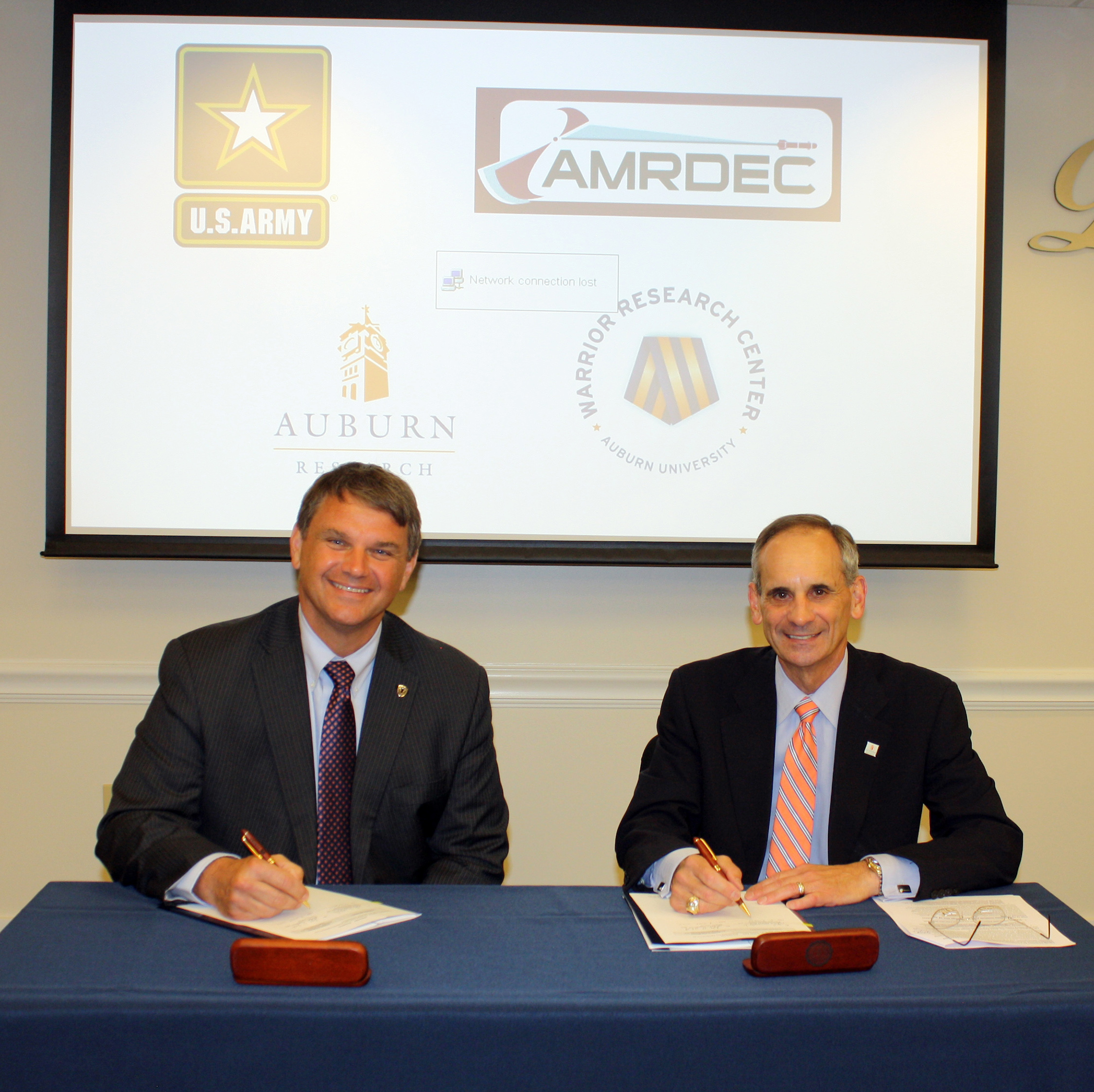 Jeff Langhout, left, acting technical director of the U.S. Army’s Aviation and Missile Research, Development and Engineering Center, signs a cooperative research and development agreement with John Mason, Auburn’s vice president for research and economic development. 