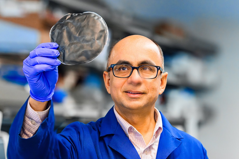 Sushil Adhikari holding paper-like biochar