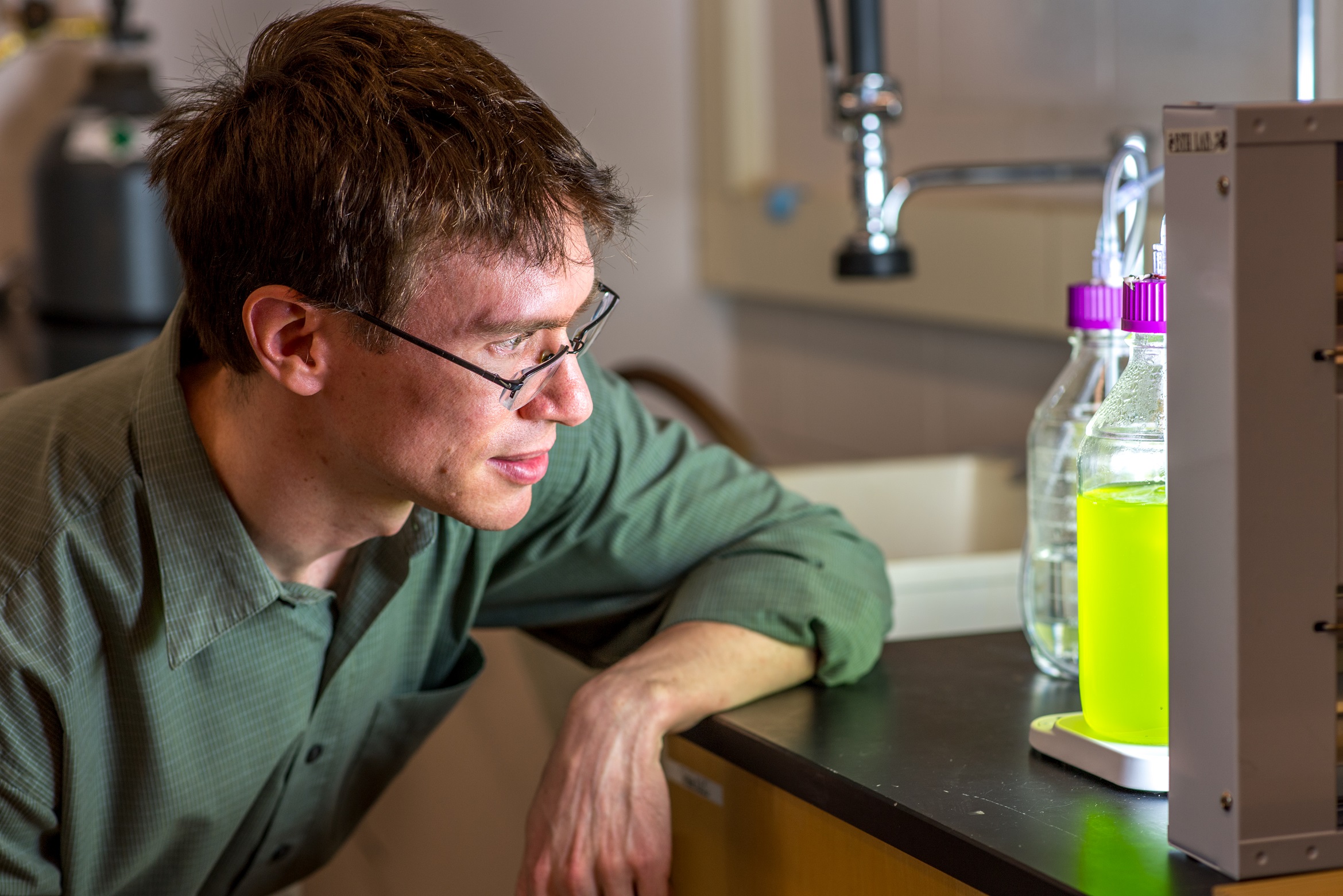 Brendan Higgins examines Chlorella algae in his lab.