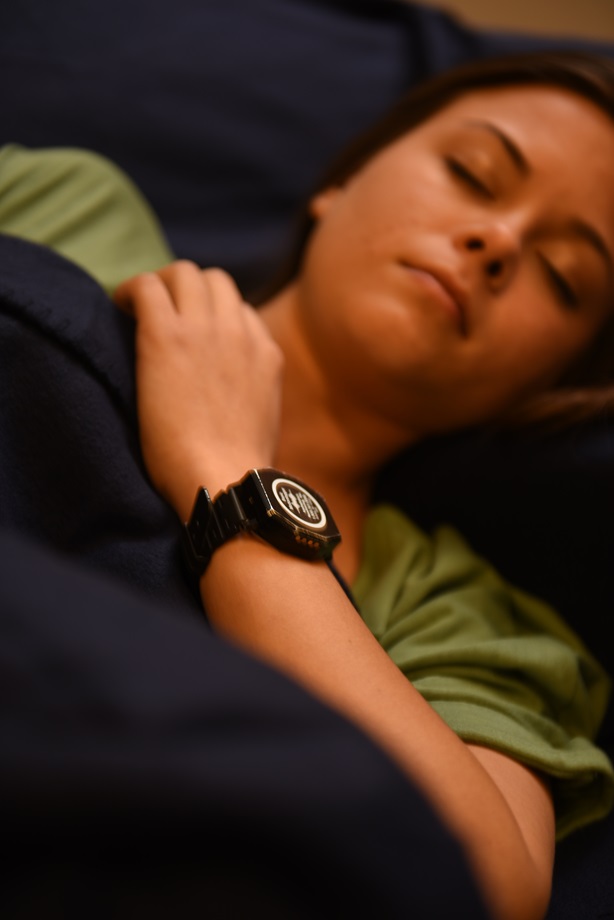 young woman with eyes closed, wearing ActiGraph monitor on her wrist