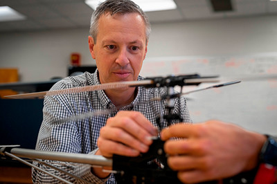 Matthew Kirchner works with a small, radio-controlled helicopter