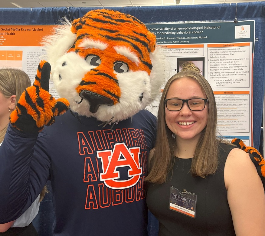 Natalie McBrayer poses with Auburn University mascot Aubie the Tiger at the 2024 Auburn Research Symposium.