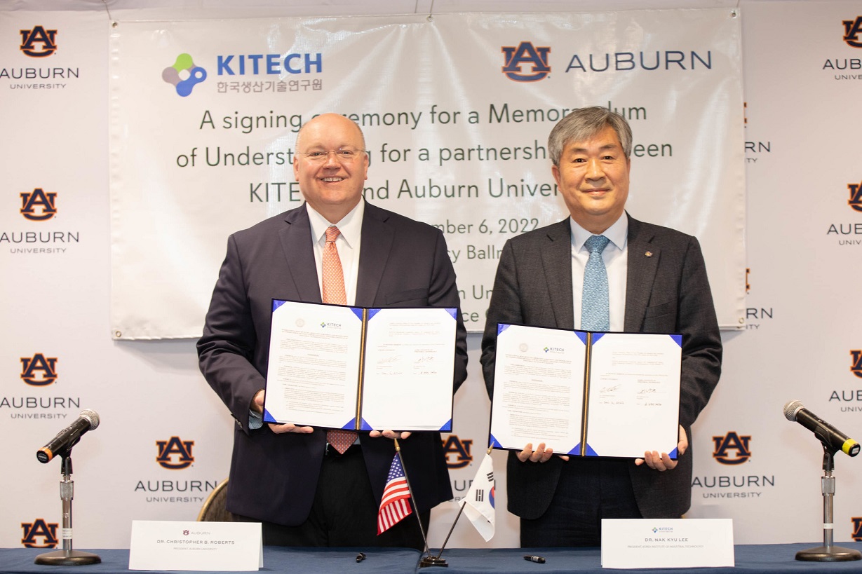 Christopher B. Roberts and Nak Kyu Lee display signed memorandum of understanding