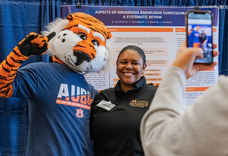 Auburn University mascot Aubie the Tiger with Makeda Nurradin, a poster presenter at the 2022 Auburn Research: Student Symposium