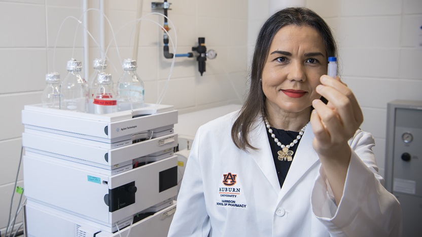 Angela Calderon holding a vial in laboratory