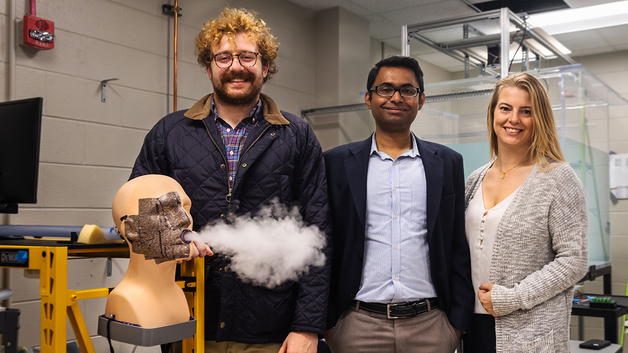 Researchers, from left, William McAtee, assistant professor Vrishank Raghav, and Sarah Morris, with 'Gloria', a mannequin cough simulator